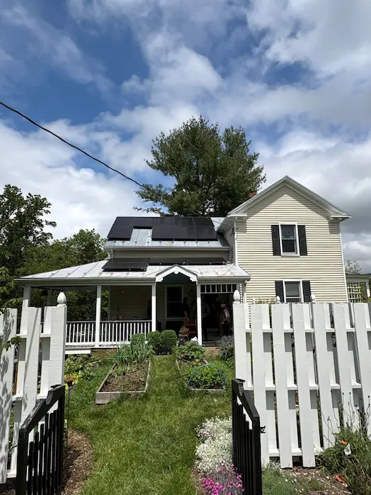 A leading Solar Company in Virginia installing high-efficiency panels on a cream-colored home with a garden.